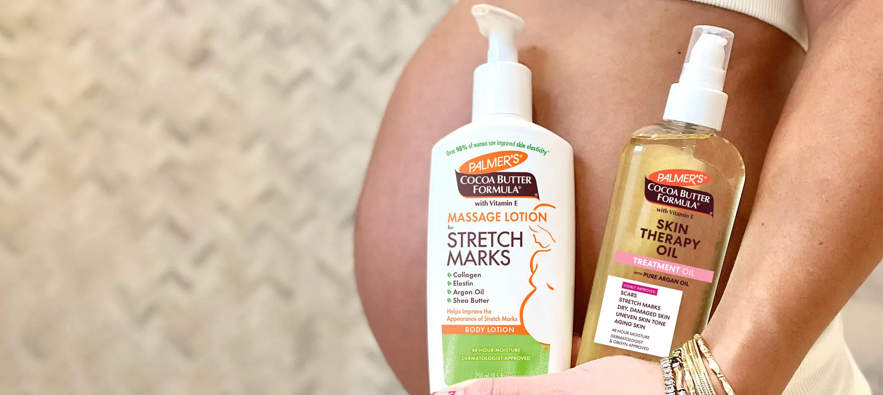 Pregnant woman holding Palmer's Massage Lotion for Stretch Marks and Skin Therapy Oil in front of belly