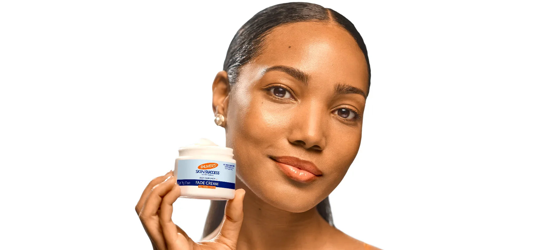 Woman holding a jar of Palmer’s Skin Success Fade Cream.