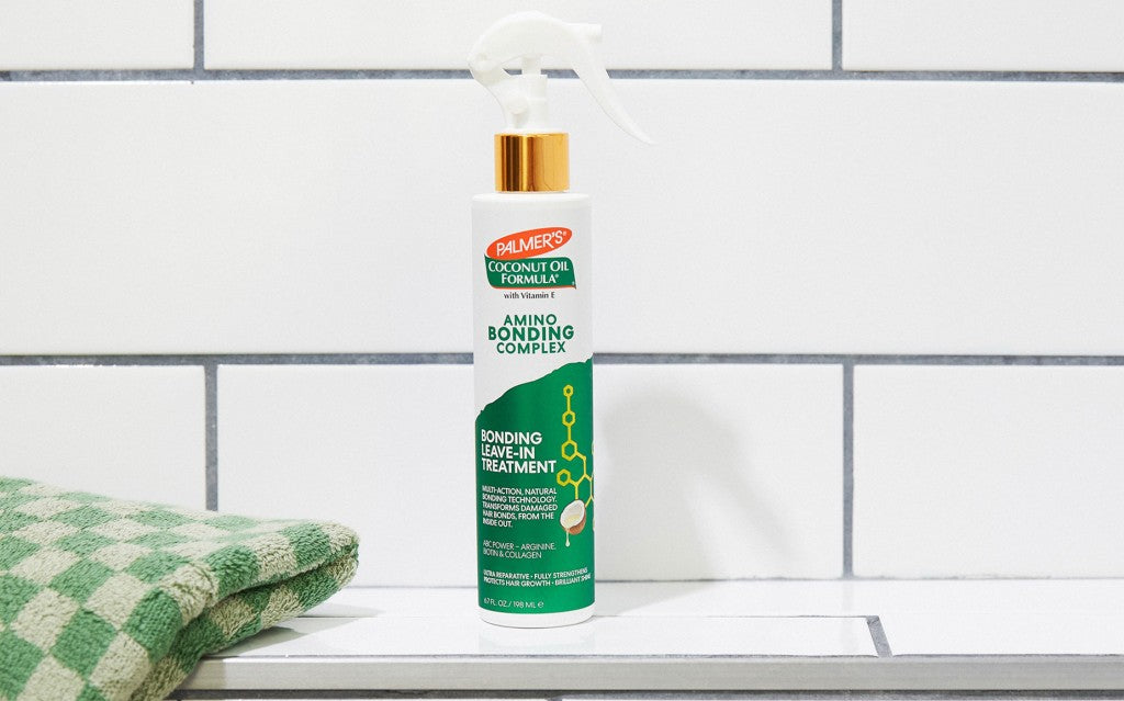 Palmer's Amino Bonding Complex Leave In Treatment for hair on tiled shower shelf with towel 