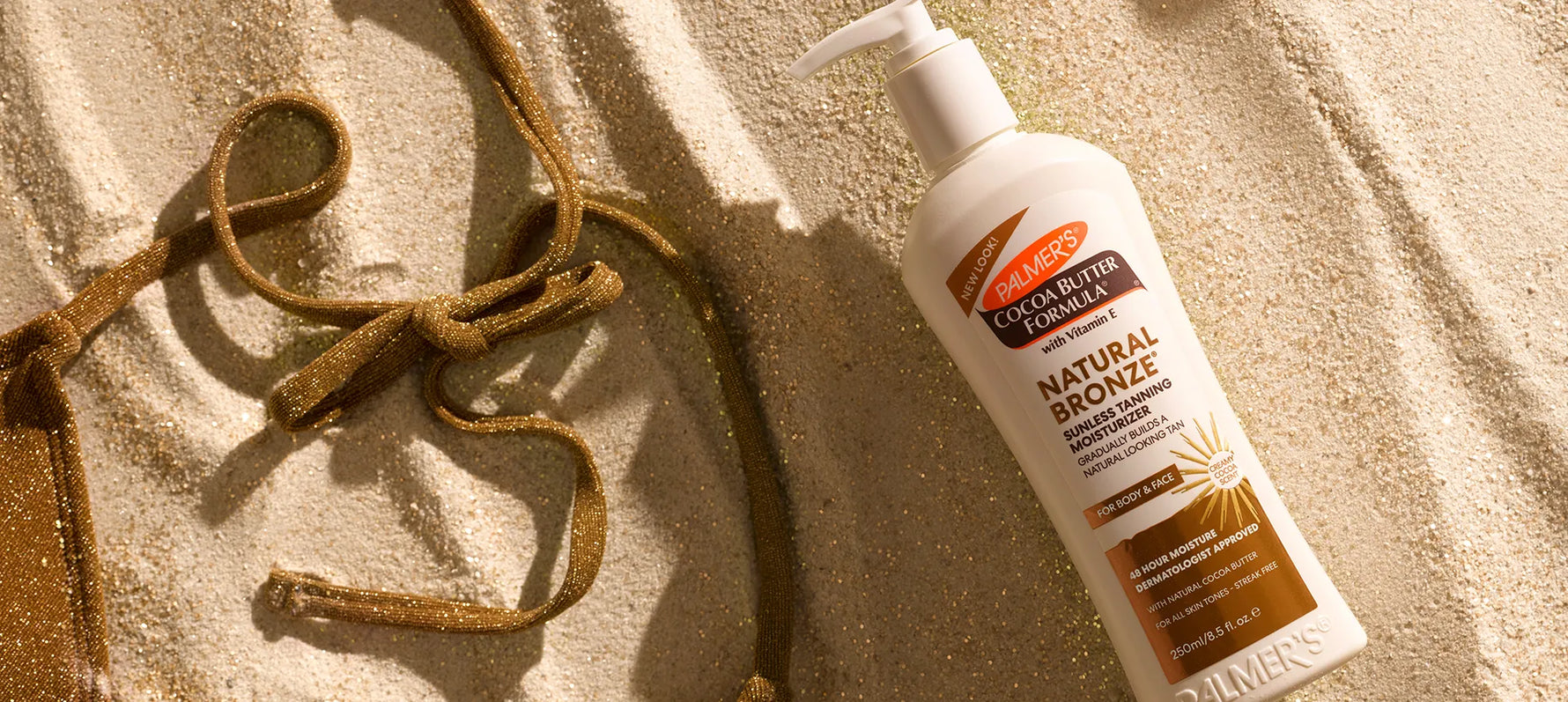 Palmer's Natural Bronze Sunless Tanner on sand with bathing suit top strings