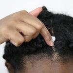 Applying Coconut Oil Gro Treatment to scalp for moisture boost.
