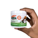 Hand holding Palmer's Coconut Oil Gro Treatment for hair moisture and shine.