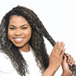 Woman applying Cocoa Butter Deep Conditioner to wet, curly hair.