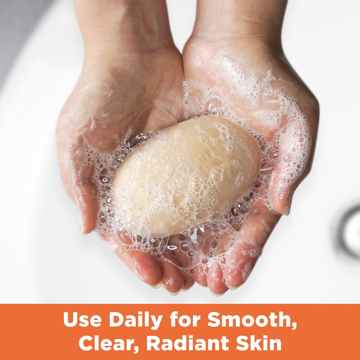 Hands holding lathered Cream Bar Soap for smooth skin.