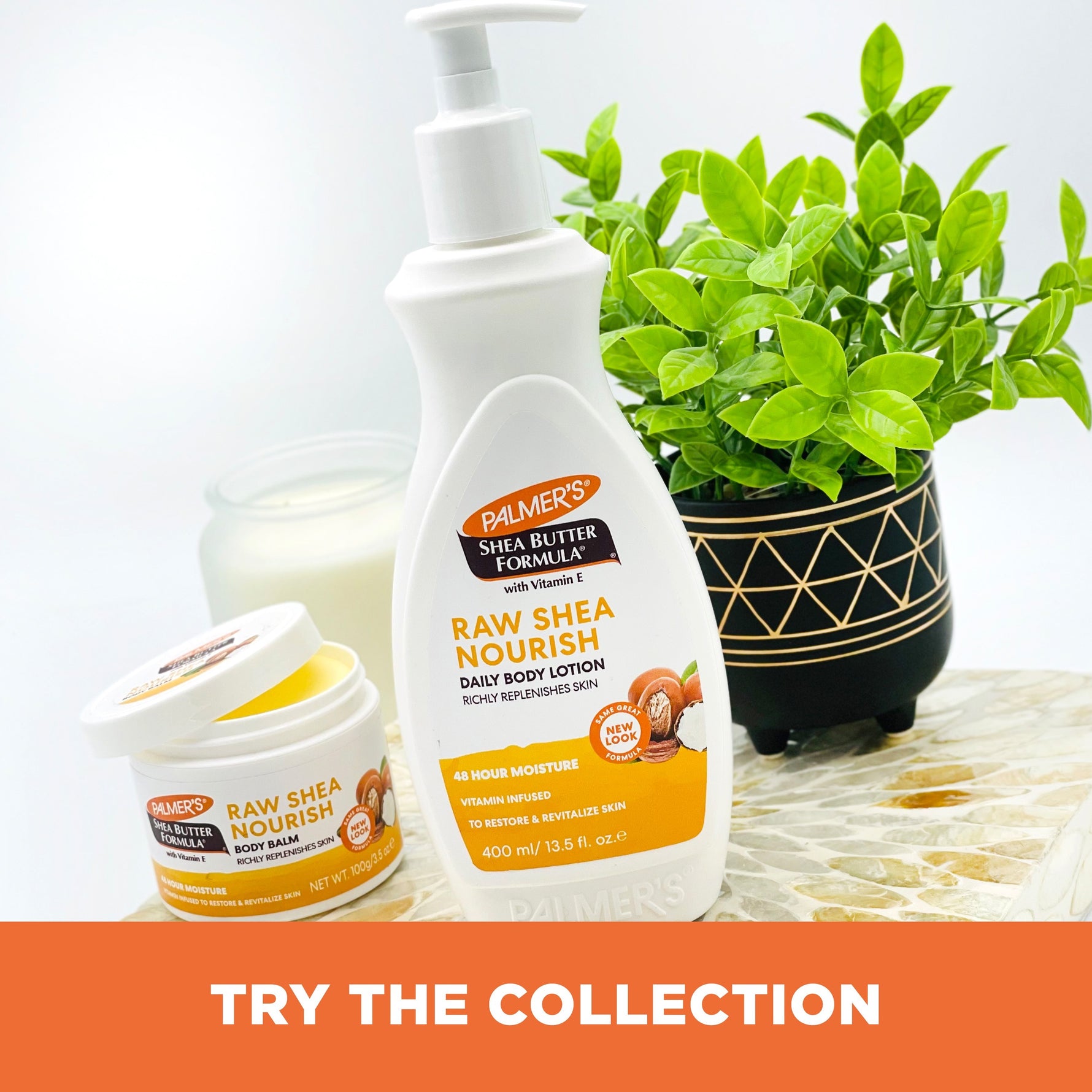 Raw Shea Nourish Body Lotion and Balm with a lit candle.