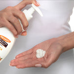 Hands dispensing Raw Shea Nourish Body Lotion from pump bottle.