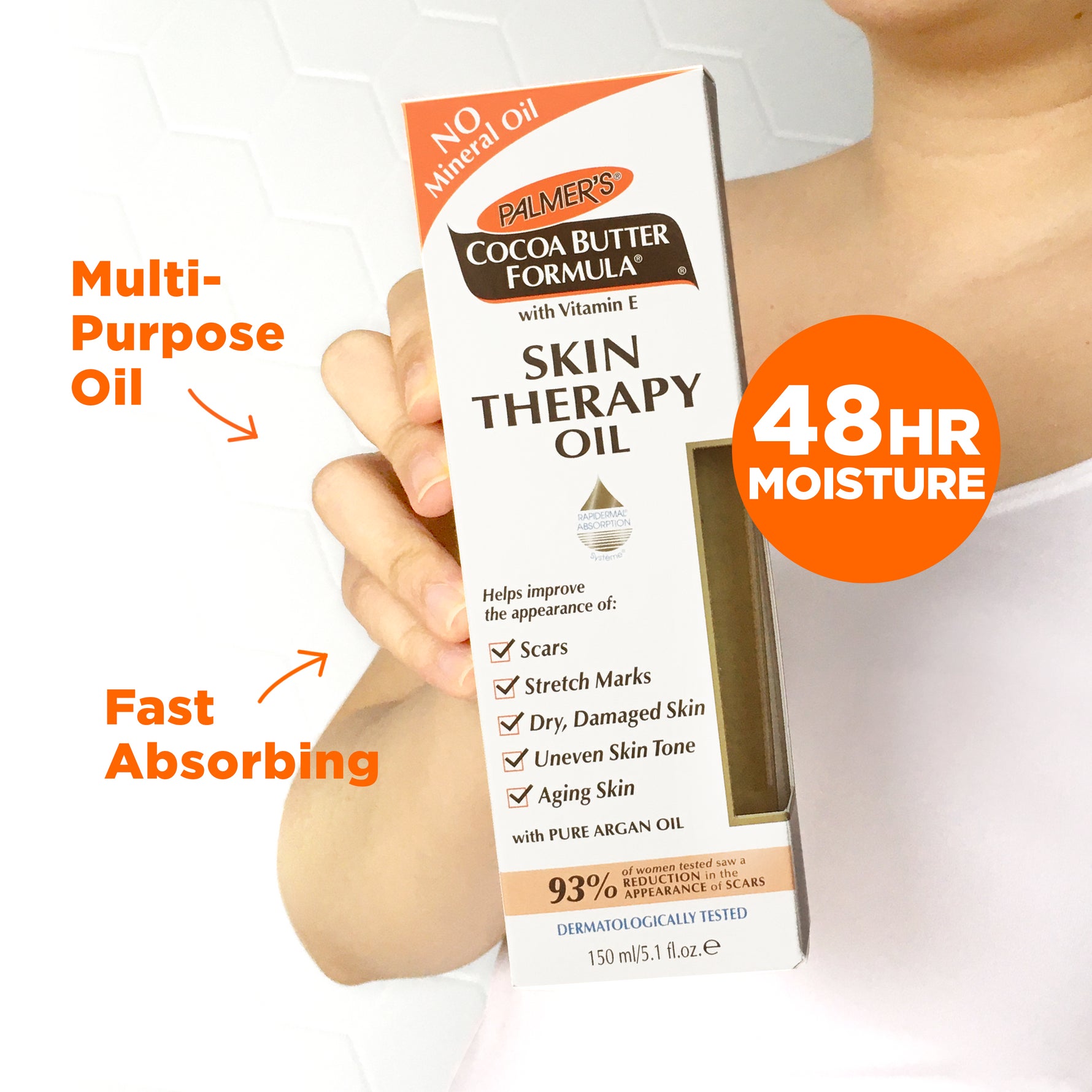 Hand holding Palmer's Cocoa Butter Skin Therapy Oil with Vitamin E box.