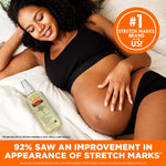 Cocoa Butter Skin Therapy Oil with Vitamin E beside smiling pregnant woman.