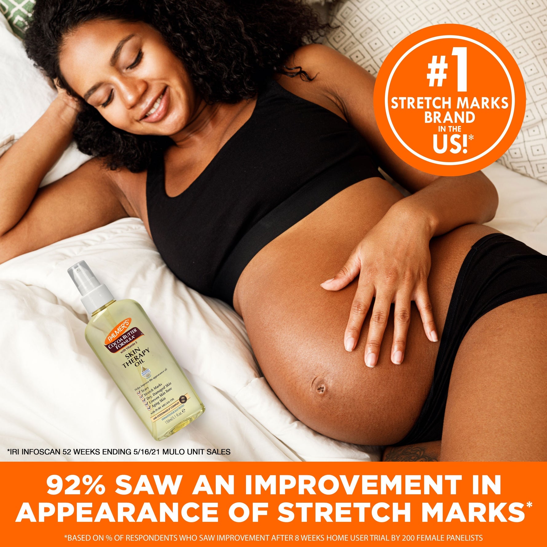 Cocoa Butter Skin Therapy Oil with Vitamin E beside smiling pregnant woman.