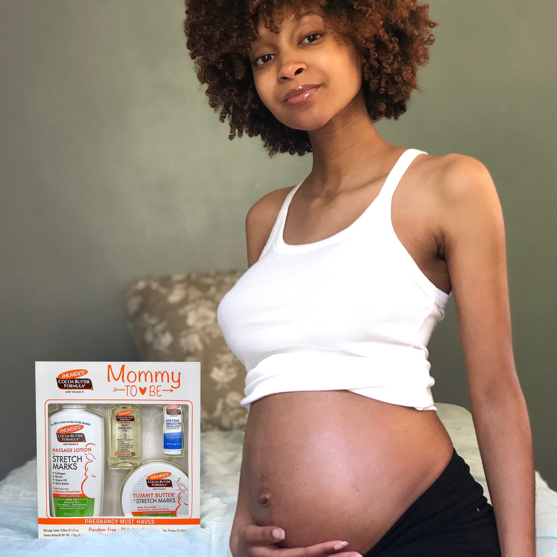 Pregnant woman with Palmer’s Mommy To Be Kit for skincare.