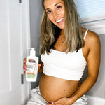 Pregnant woman holding Palmer's Mommy To Be Kit lotion bottle.