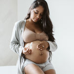 Pregnant woman applying Palmer's Cocoa Butter Mommy To Be Kit.