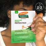 Person holding Palmer's Coconut Oil Protein Pack sachet for moisture treatment.