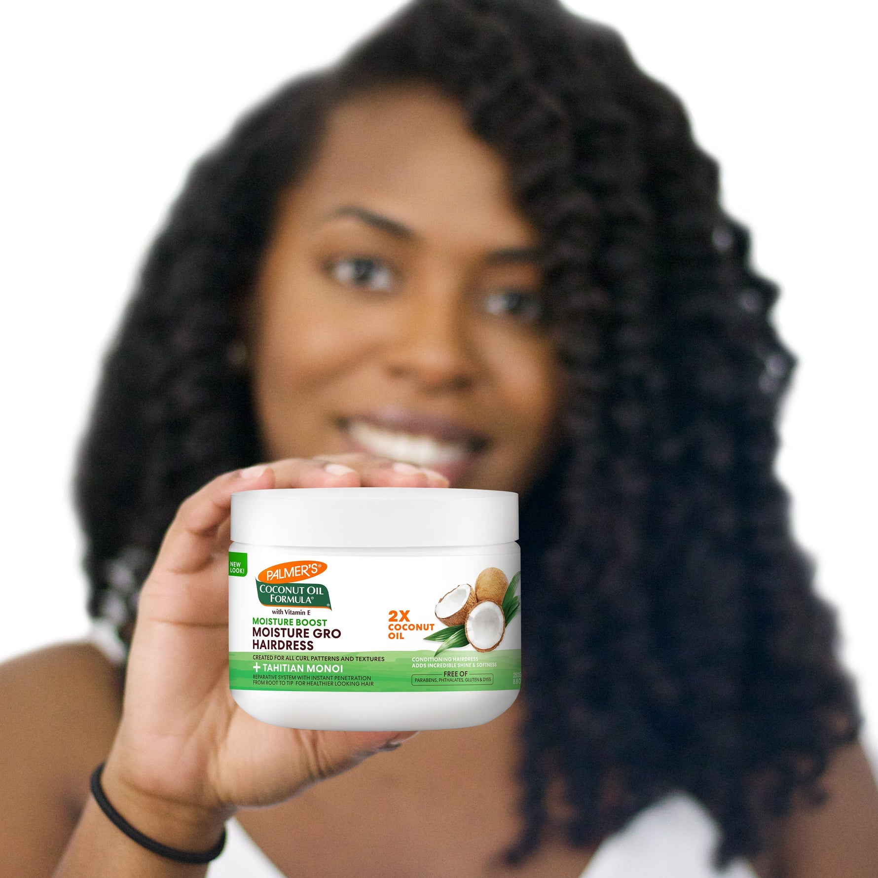 Woman holding Palmer's Coconut Oil Gro Treatment for hair nourishment.
