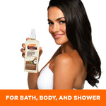 Woman showcasing Palmer's Coconut Hydrate Body Oil pump-bottle.