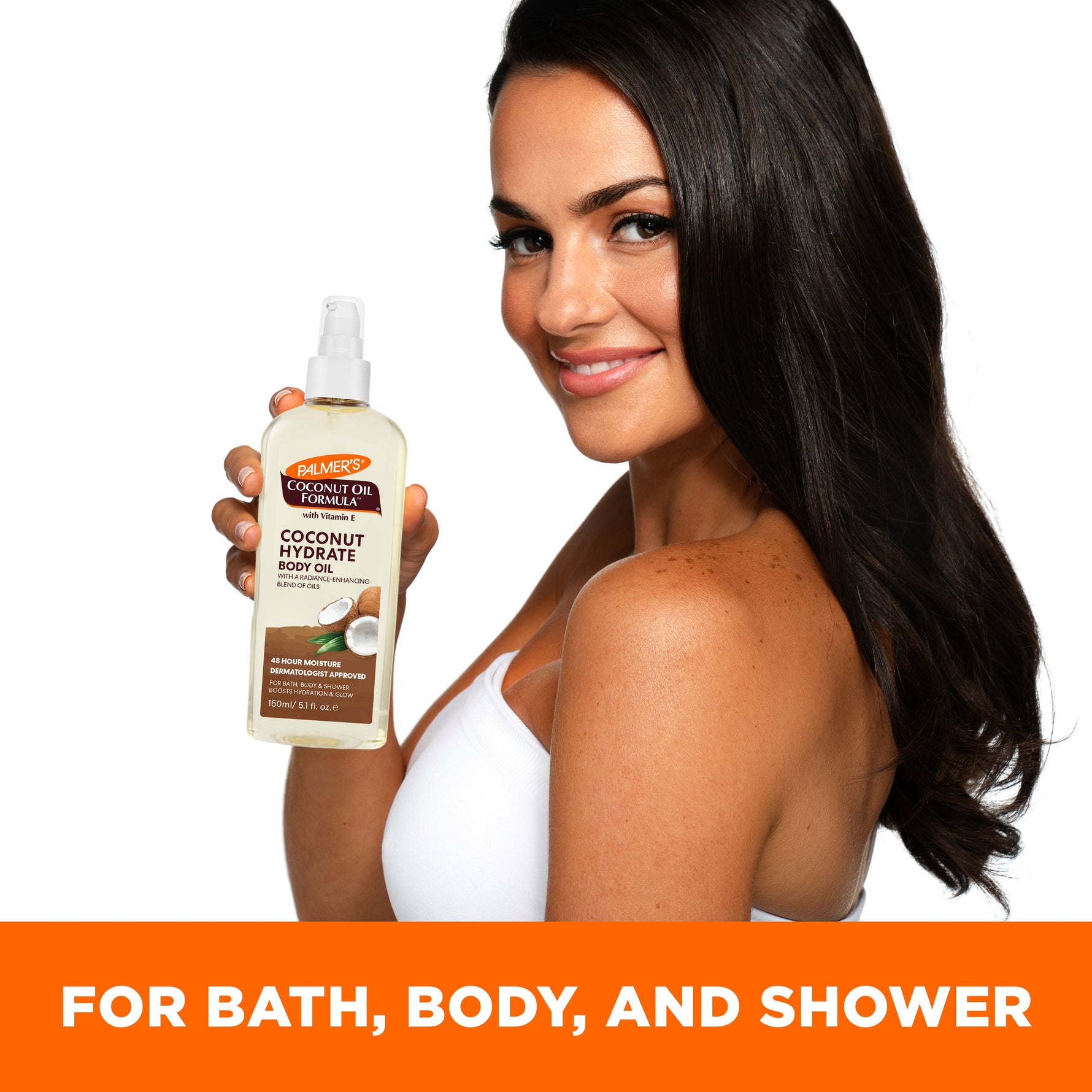 Woman showcasing Palmer's Coconut Hydrate Body Oil pump-bottle.