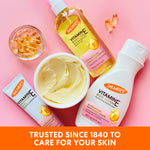 Palmer’s Vitamin E Concentrated Cream amidst skincare range on pink background.