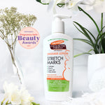 Cocoa Butter Massage Lotion bottle with award badge and flowers.