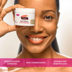 Woman holding a jar of Palmer's Cocoa Butter Formula Skin Therapy Retinol-10 Cream with text about its benefits.